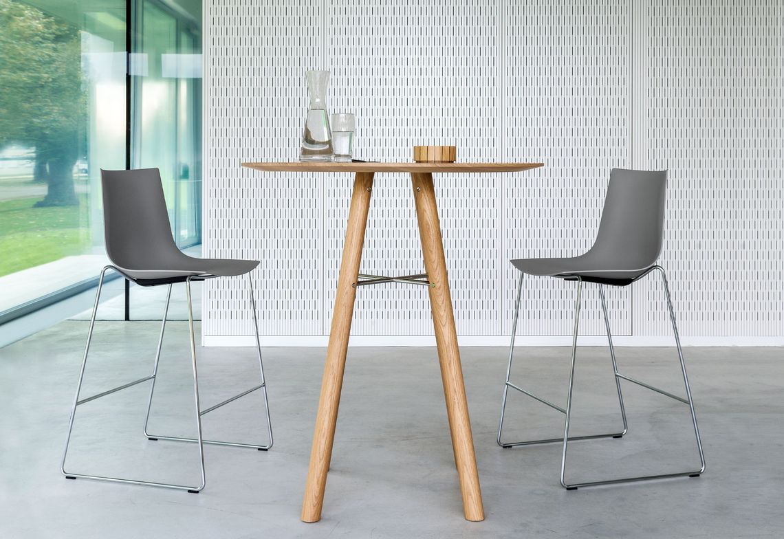 Kufenstuhl hoch, Küchen- oder Barhocker mit Kunststoffschale in silber am hohen Akio Massivholztisch rund 