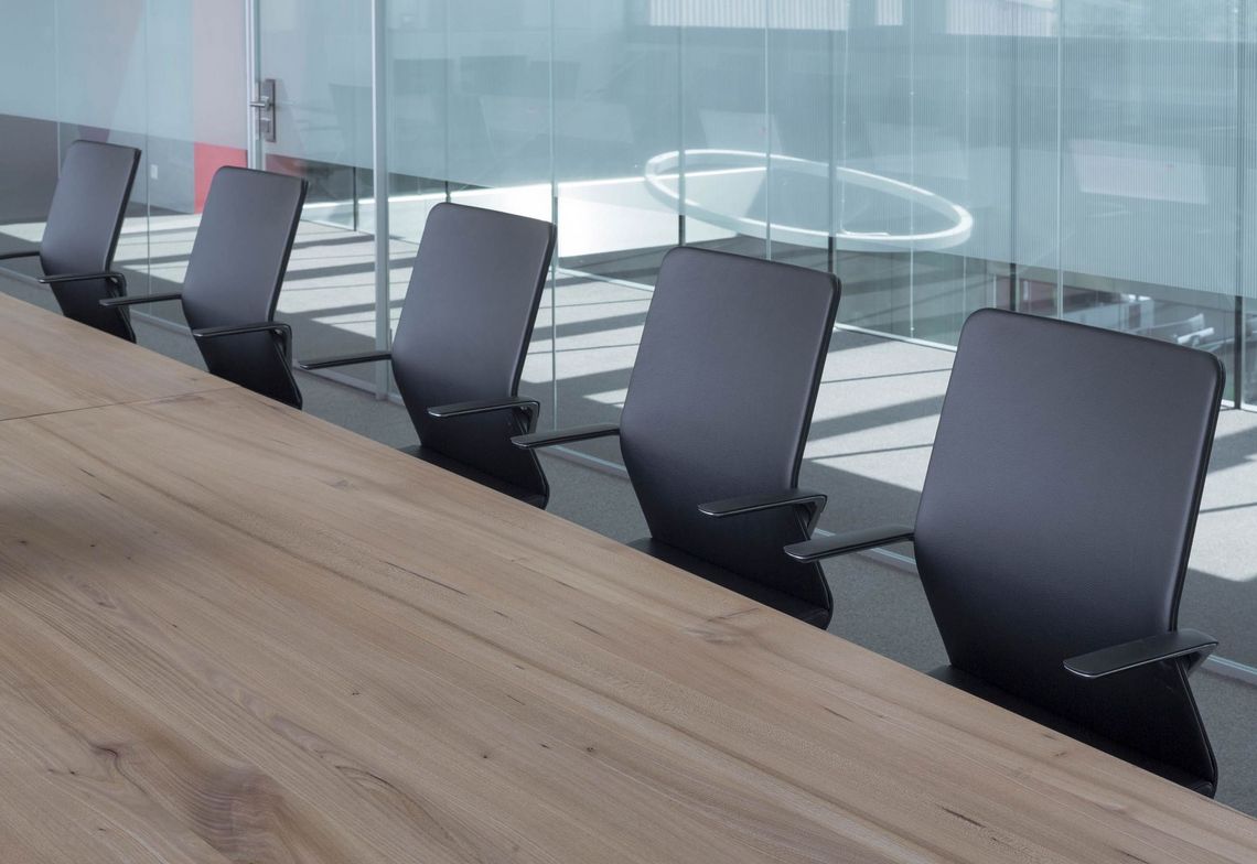 Besprchungstisch Nahaufnahme vom Massivholztischblatt und Konferenzstühlen