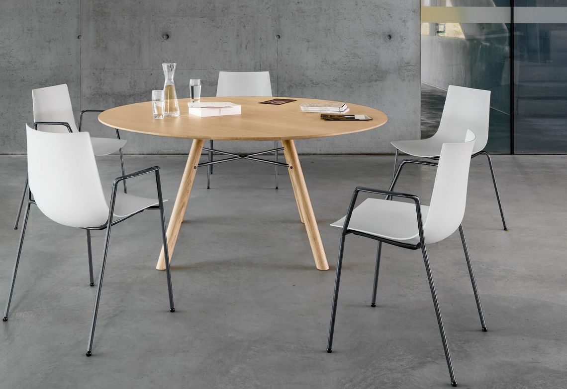 Stuhl mit schwarzem Vierbeingestell und weisser Kunststoffschale mit und ohne Armlehnen am Akio Massivholztisch rund