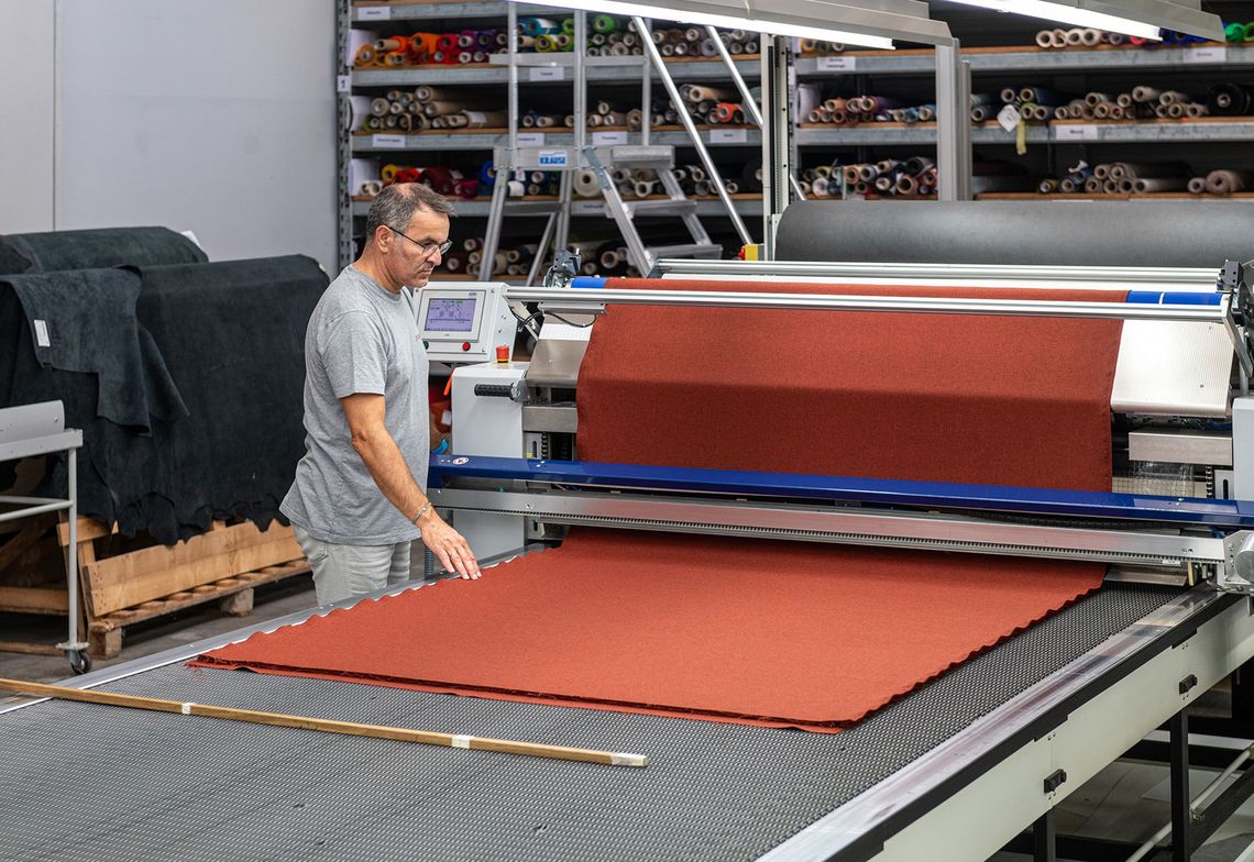 Découpe du tissu pour les nouveaux revêtements des sièges pliants du manège.