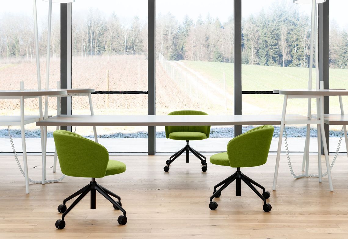 Konferenstuhl mit scharzem Viersternfuss und Rollen in einer Besprechungssituation