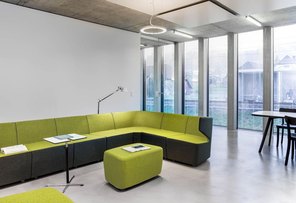 Sitzgruppe Büro grün und grau zweifarbig gepolstert, mit Arbeitstisch im Aufenthaltsraum im Büro