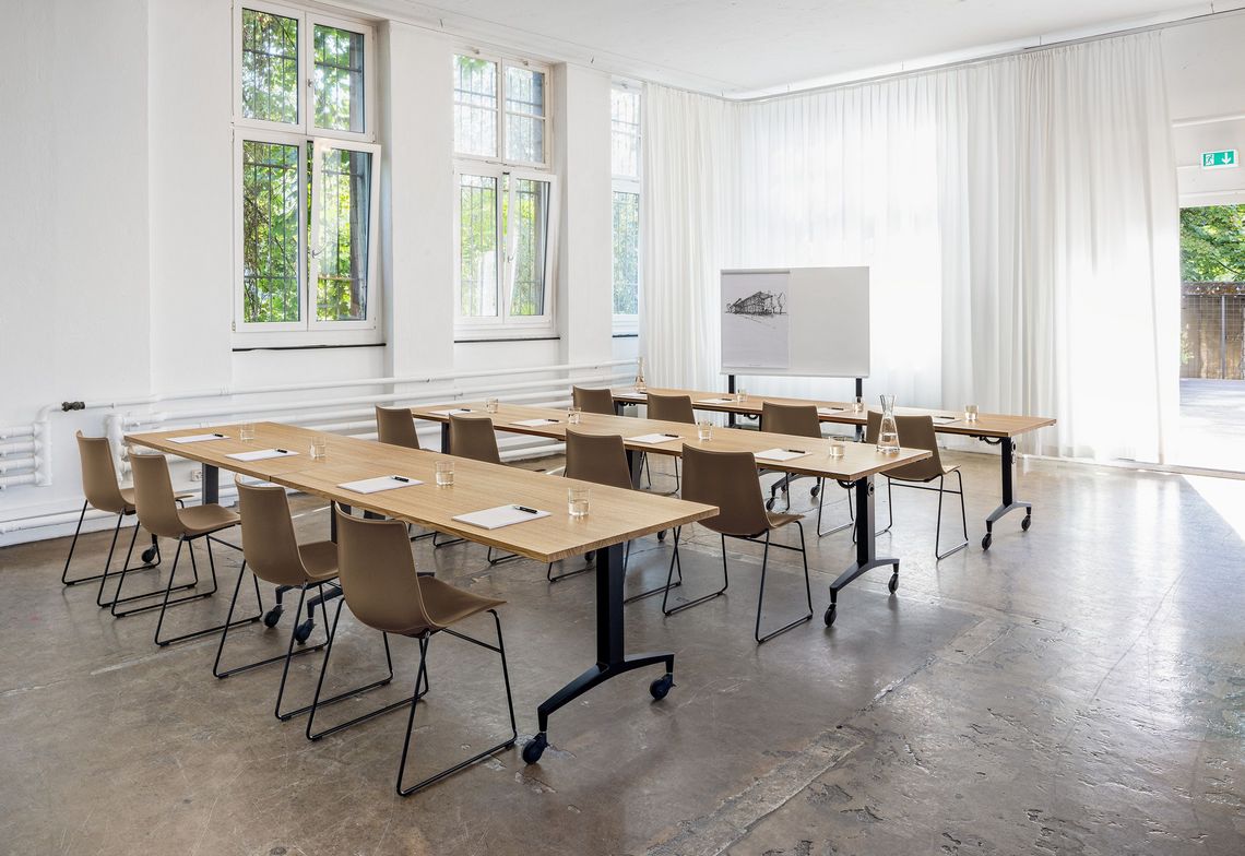 Alteo Klapptisch in drei Tischreihen aufgebaut in einem Schulungsraum mit Kufenstühlen Nava sowie dem Alteo Whiteboard