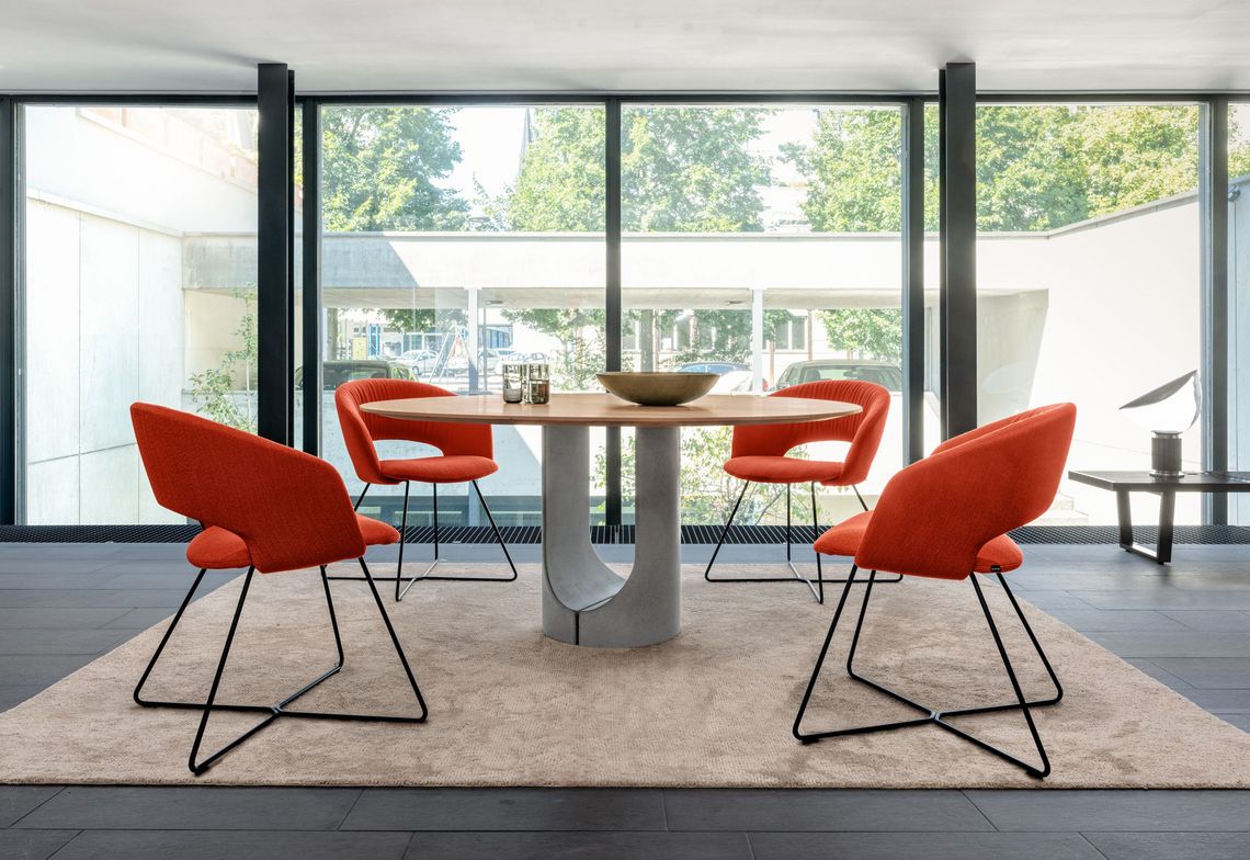 Stühle Esszimmer Calina mit schwarzem Kufengestell und orangefarbiger Komfortausführung am Udina Tisch