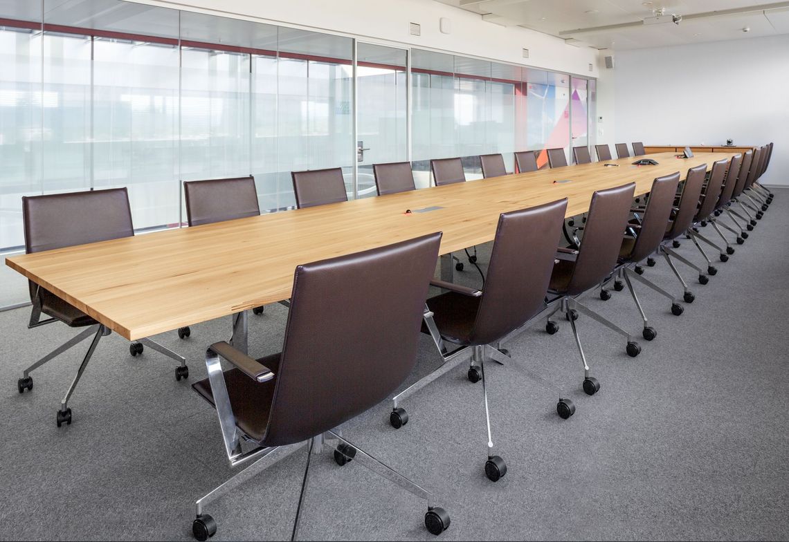 Adapt Konferenztisch Massivholz mit Medienklappe mit Jack Konferenzstühlen im Sitzungszimmer 