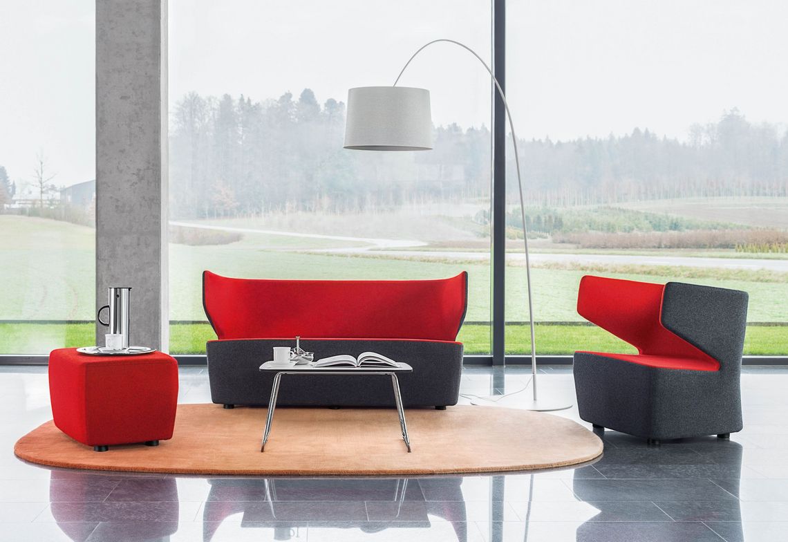 Loungesofa, Sessel, Polsterhocker und kleiner Beistelltisch im Empfangsbereich