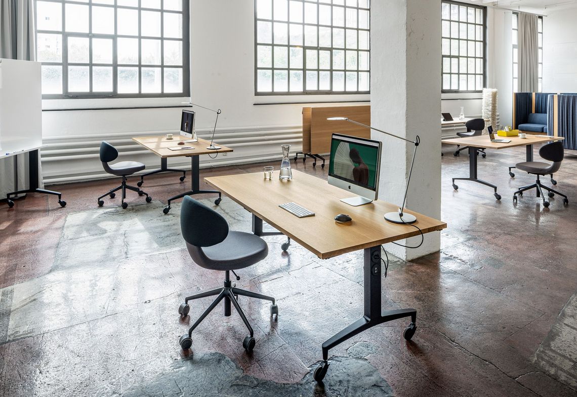Vier Einzelarbeitsplätze im Großraumbüro mit dem Alteo Klapptisch und Whiteboard sowie Simplex Bürostuhl