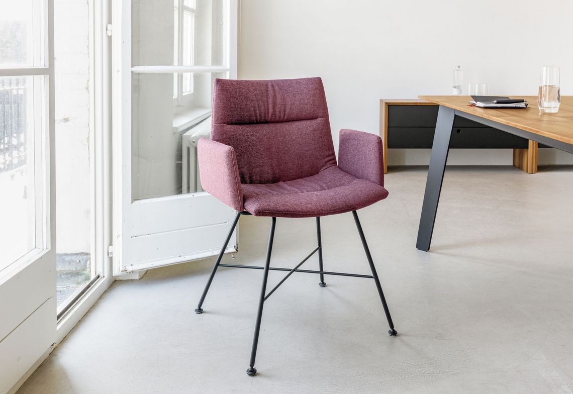 Polsterstuhl mit Armlehne und schwarzem Vierfussgestell im Homeoffice