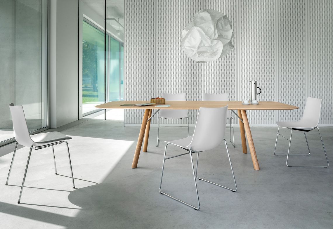 Kufenstuhl und Vierbeinstuhl mit weisser Kunststoffschale am Akio Massivholztisch