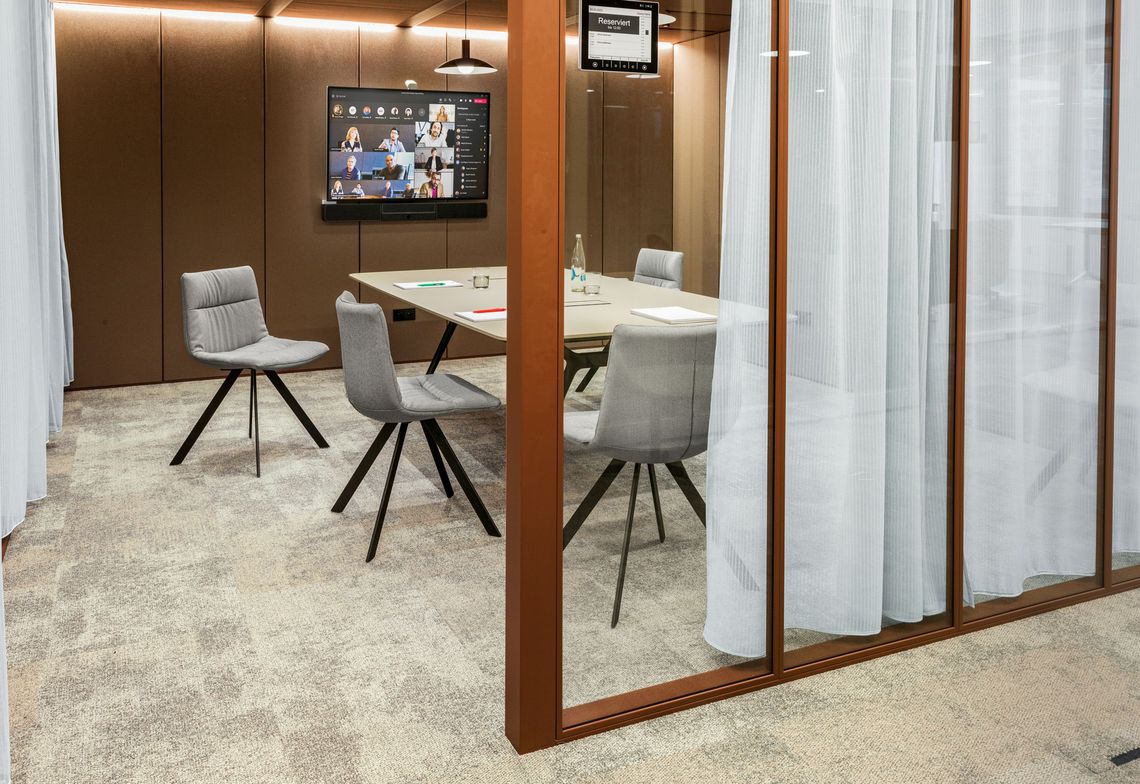 Polsterstuhl mit schwarzem Flachrohrgestell am Konferenztisch